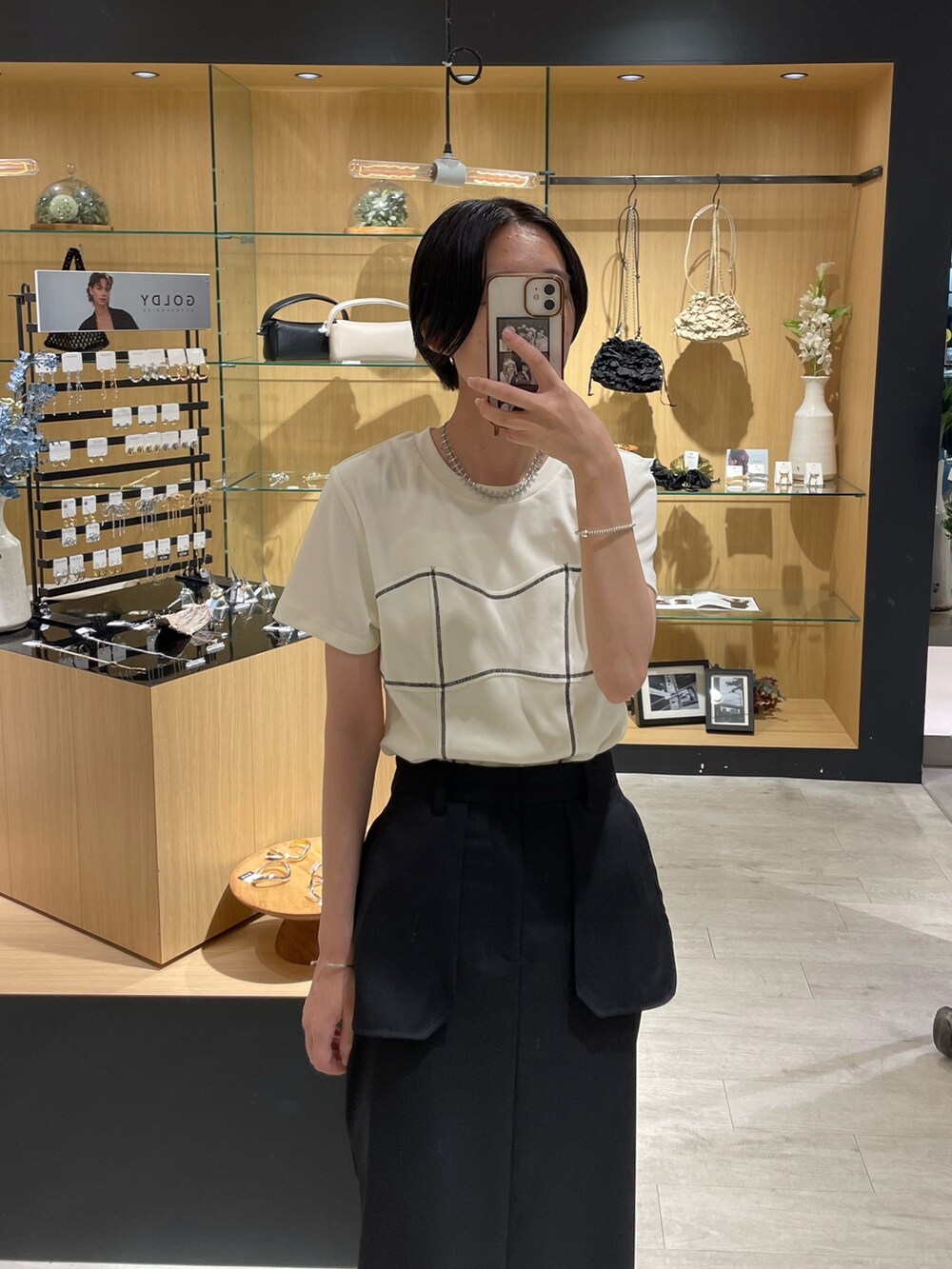 ホワイト系のTシャツ/カットソー、ブラック系のスカートを着用したレディースの夏コーディネートの2枚目の写真