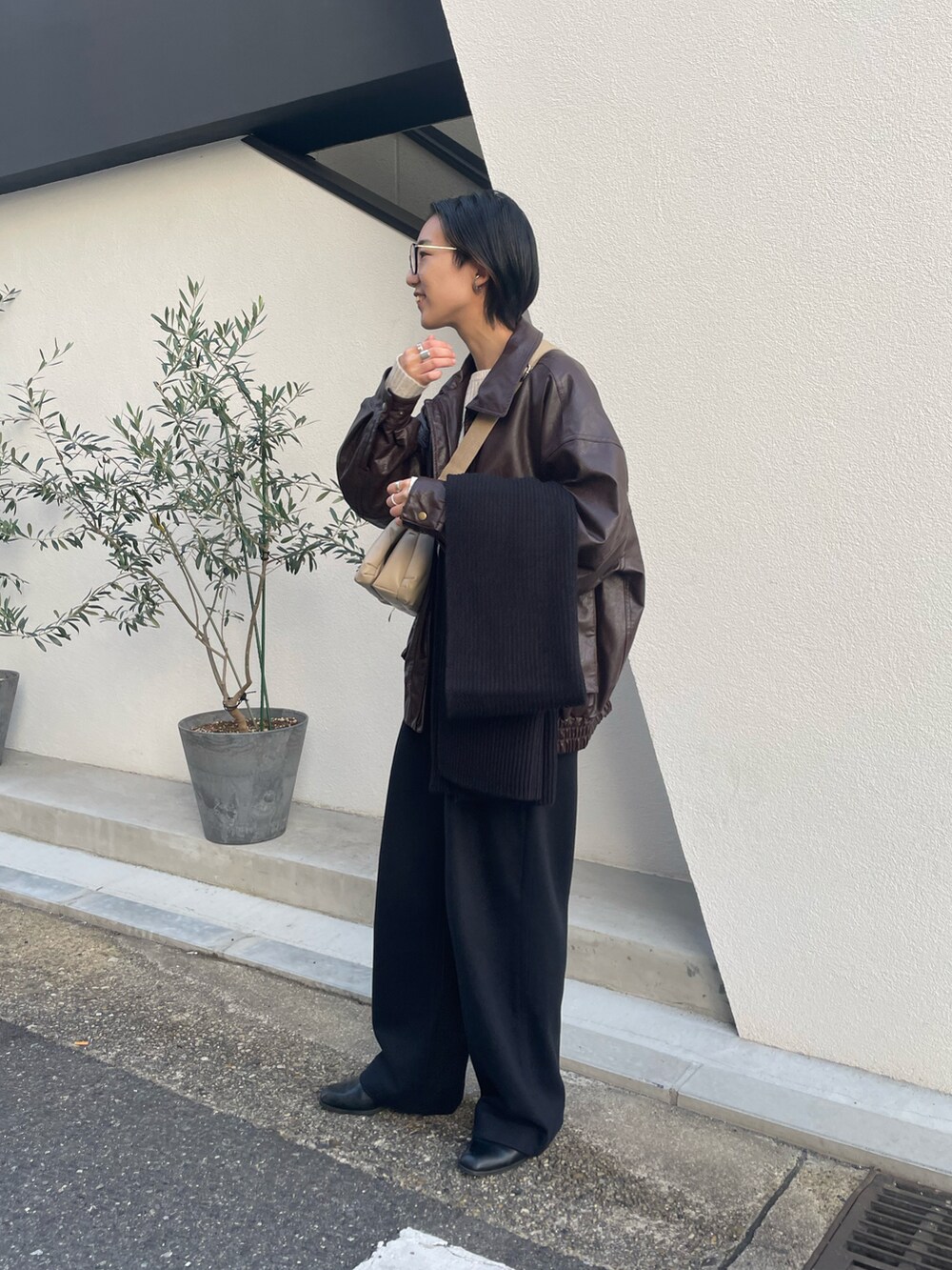 ブラック系のパンツ、ベージュ系のニット/セーター、ブラック系のマスクを着用したレディースの冬コーディネートの4枚目の写真