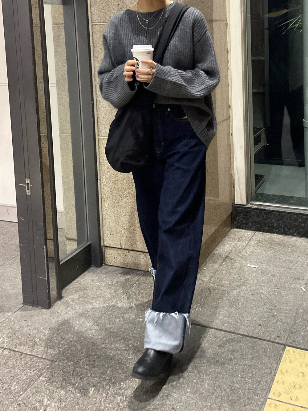 ブルー系のデニムパンツ、グレー系のニット/セーターを着用したレディースの冬コーディネートの4枚目の写真