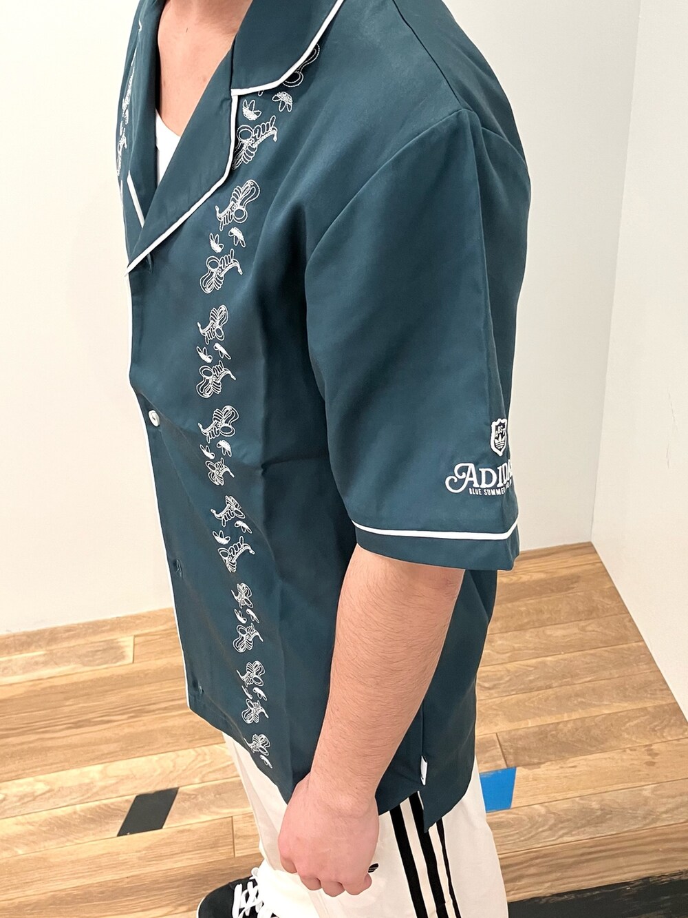 ブルー系のTシャツ/カットソー、ブラック系のスニーカー、ホワイト系のスウェットパンツを着用したメンズの春コーディネートの3枚目の写真