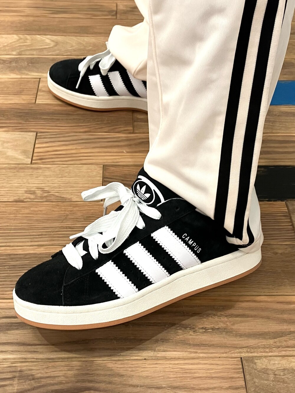 ブルー系のTシャツ/カットソー、ブラック系のスニーカー、ホワイト系のスウェットパンツを着用したメンズの春コーディネートの4枚目の写真