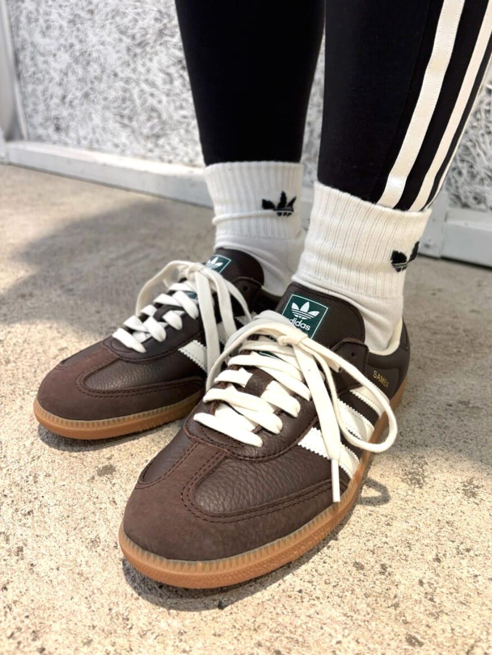 ブラック系のショルダーバッグ、ブラウン系のトップス、ブラウン系のスニーカーを着用したレディースの秋コーディネートの6枚目の写真