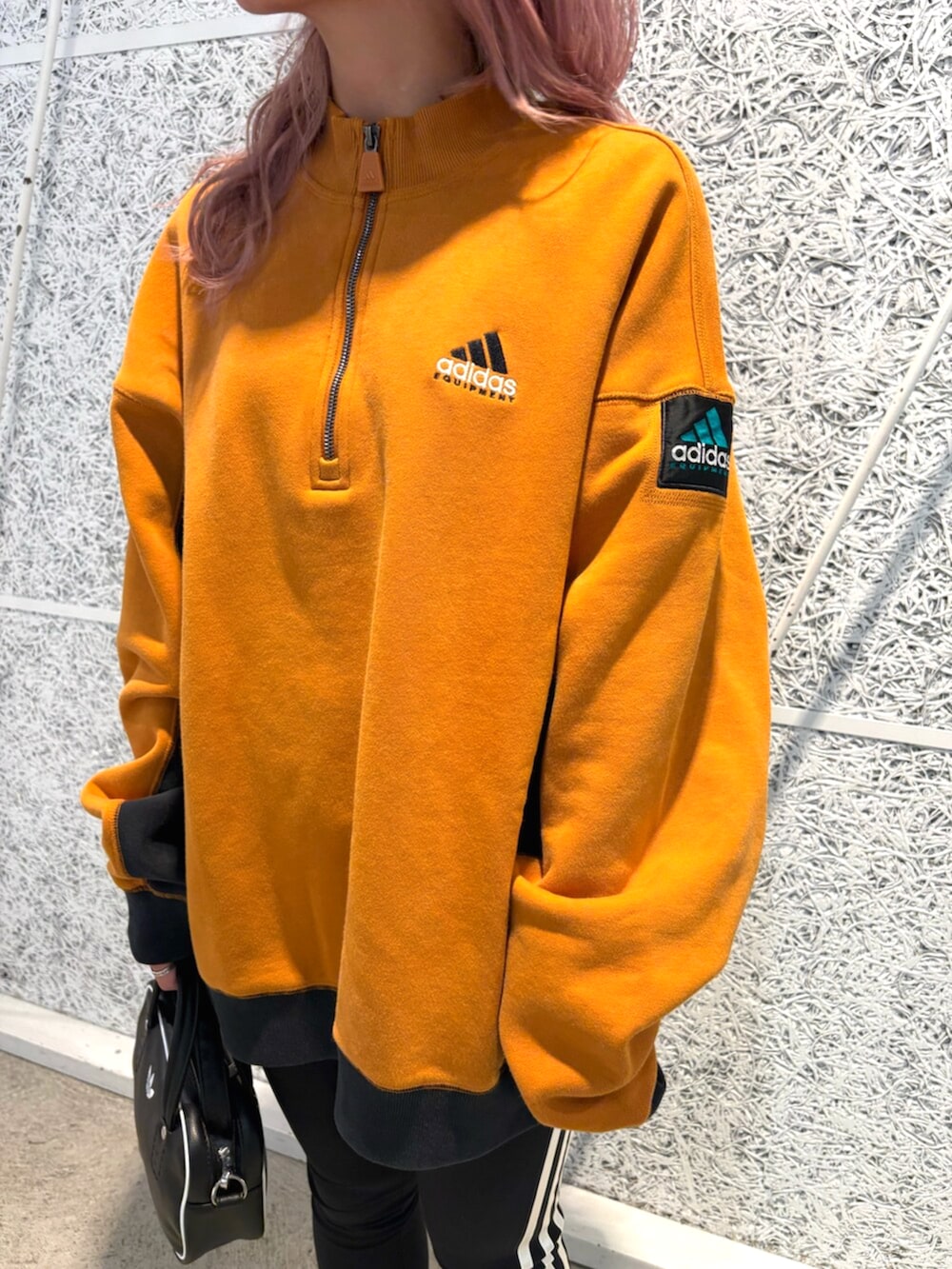 ブラック系のショルダーバッグ、ブラウン系のトップス、ブラウン系のスニーカーを着用したレディースの秋コーディネートの3枚目の写真