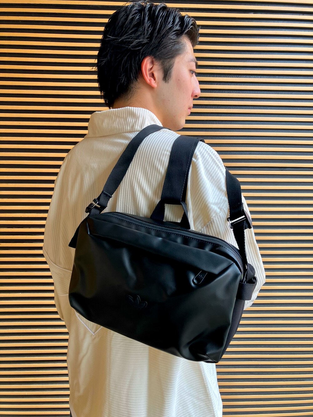 ホワイト系のブルゾン、ブラック系のボディバッグ/ウエストポーチ、ブラック系のシューズを着用したメンズの秋コーディネートの4枚目の写真