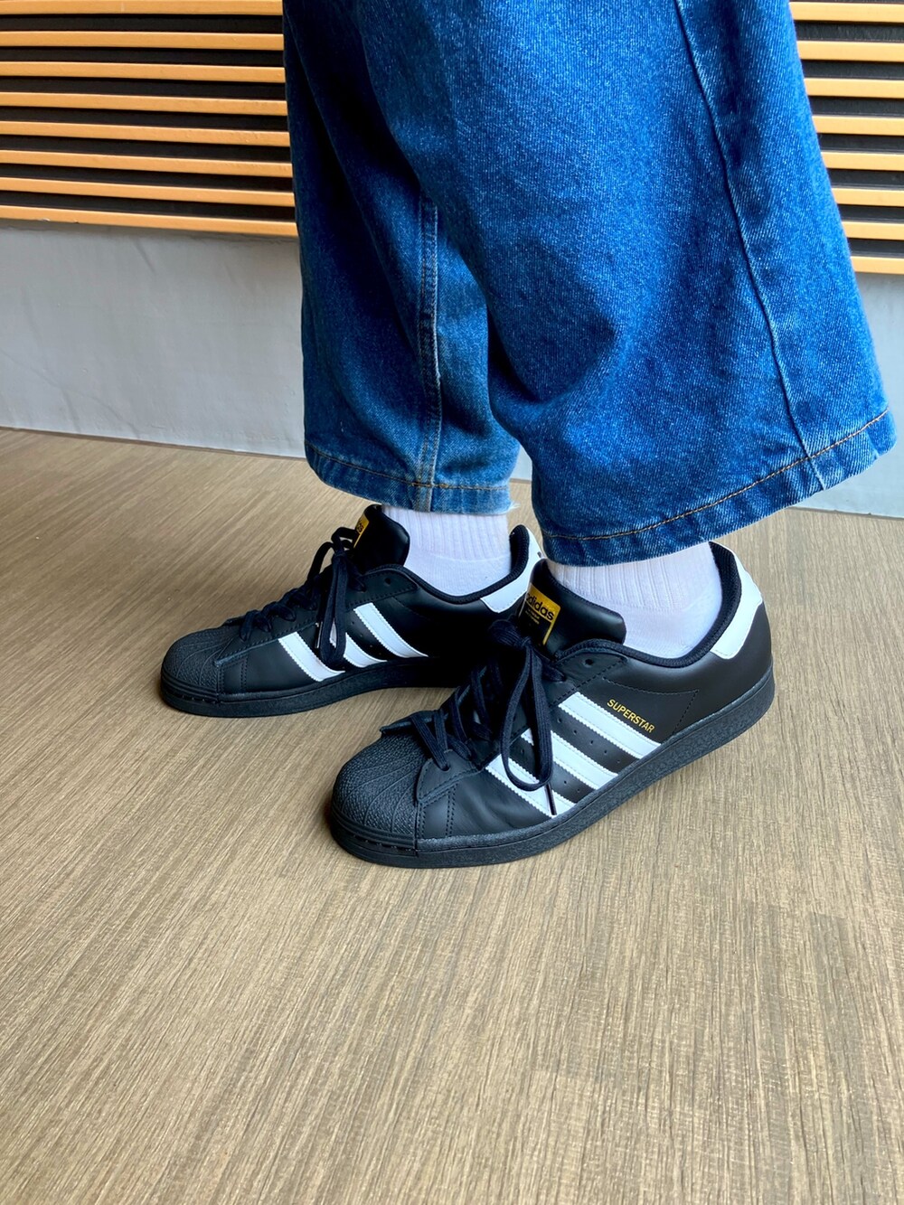 ホワイト系のブルゾン、ブラック系のボディバッグ/ウエストポーチ、ブラック系のシューズを着用したメンズの秋コーディネートの5枚目の写真