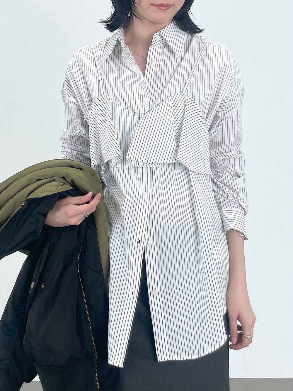 グレー系のワンピース、レッド系のパンプス、ブラック系のMA-1を着用したレディースの秋コーディネートの4枚目の写真