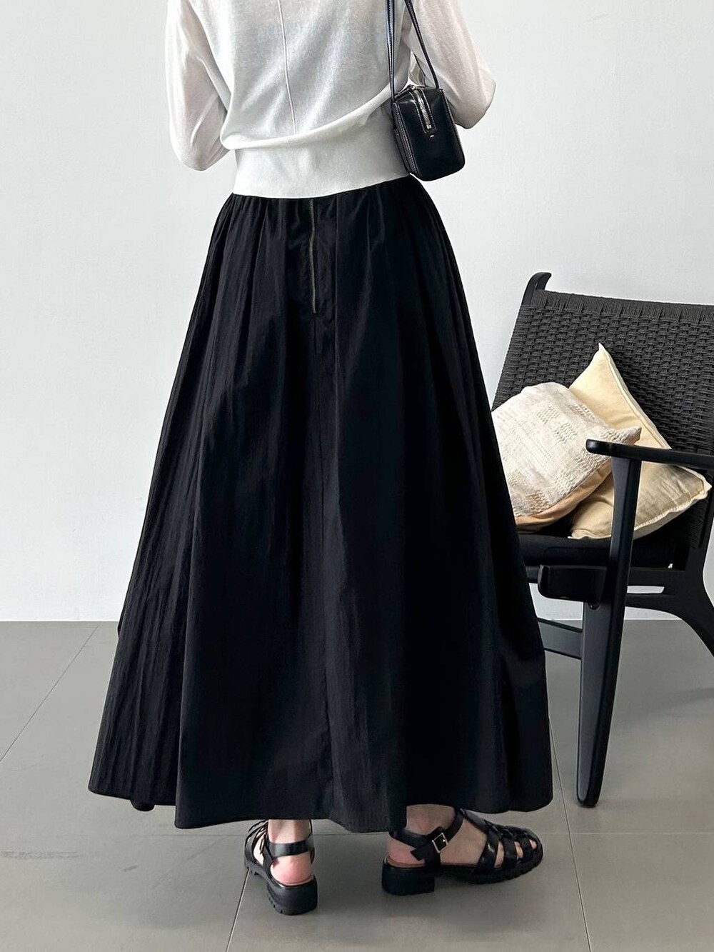 ホワイト系のカーディガン/ボレロ、ブラック系のサンダル、ブラック系のスカートを着用したレディースの春コーディネートの6枚目の写真