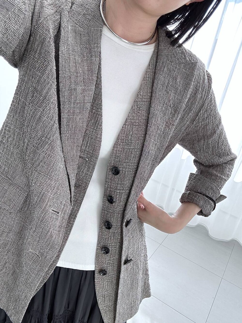 ブラック系のハンドバッグ、ブラック系のテーラードジャケット、ブラック系のベストを着用したレディースの冬コーディネートの6枚目の写真