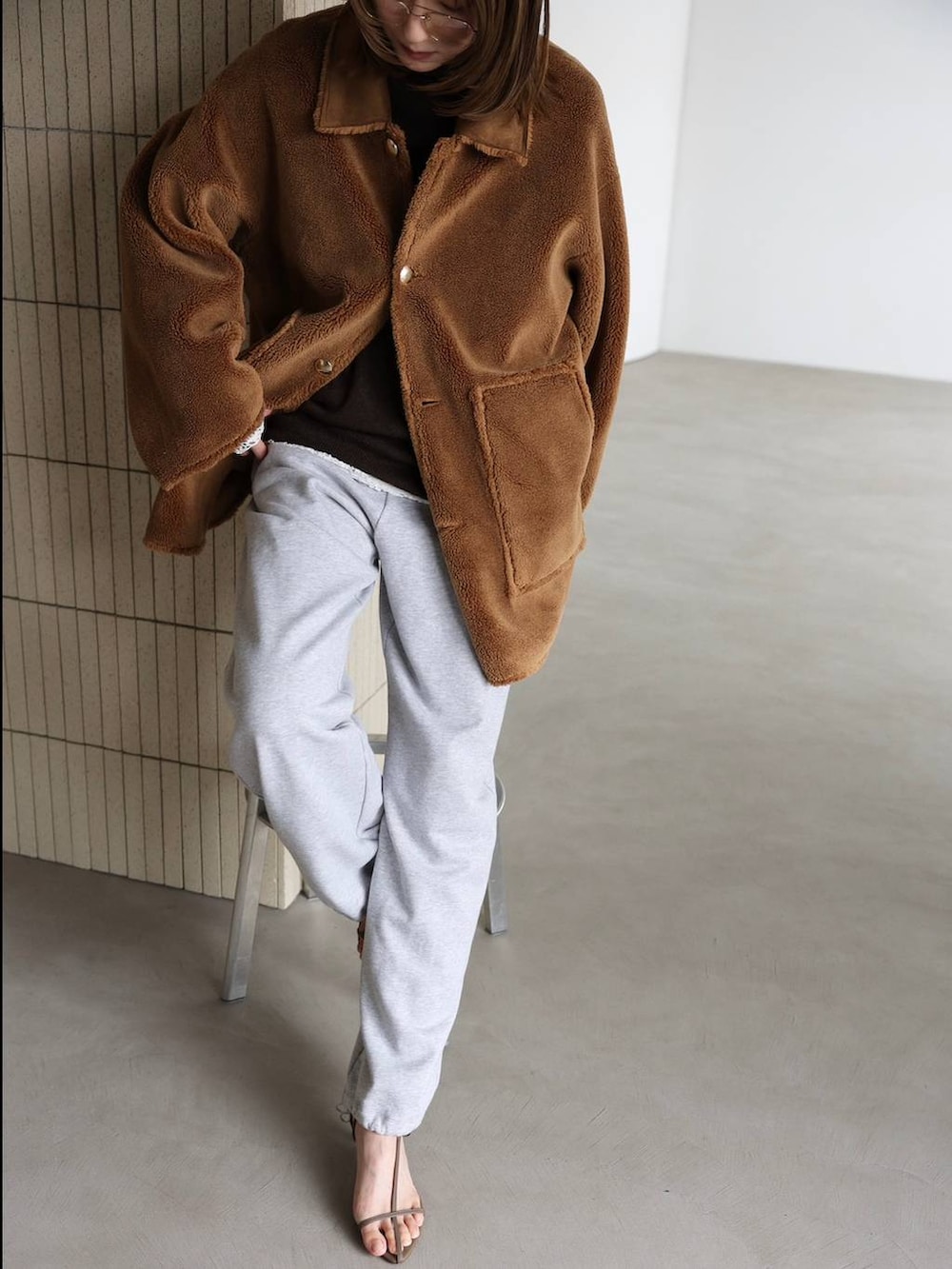 ホワイト系のTシャツ/カットソー、ベージュ系のサンダル、グレー系のスウェットパンツを着用したレディースの秋コーディネートの5枚目の写真