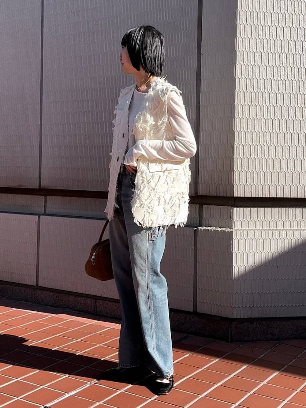 ホワイト系のTシャツ/カットソー、ホワイト系のベスト、ブルー系のデニムパンツを着用したレディースの冬コーディネートの2枚目の写真