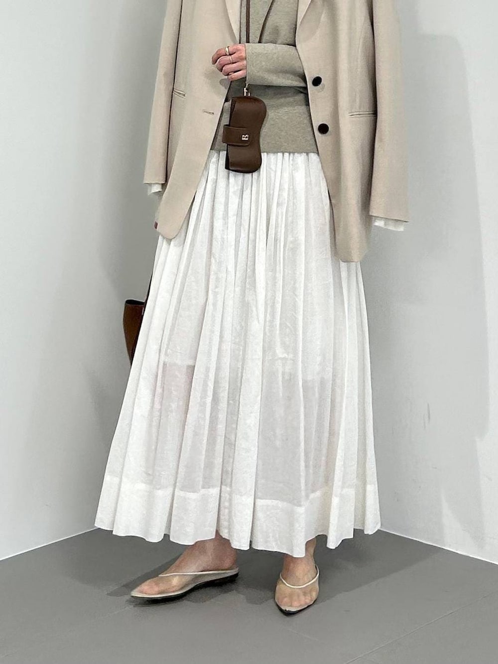 ベージュ系のパンプス、ベージュ系のテーラードジャケット、ホワイト系のスカートを着用したレディースの冬コーディネートの4枚目の写真