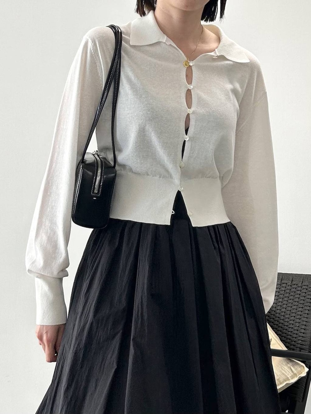 ホワイト系のカーディガン/ボレロ、ブラック系のサンダル、ブラック系のスカートを着用したレディースの春コーディネートの3枚目の写真