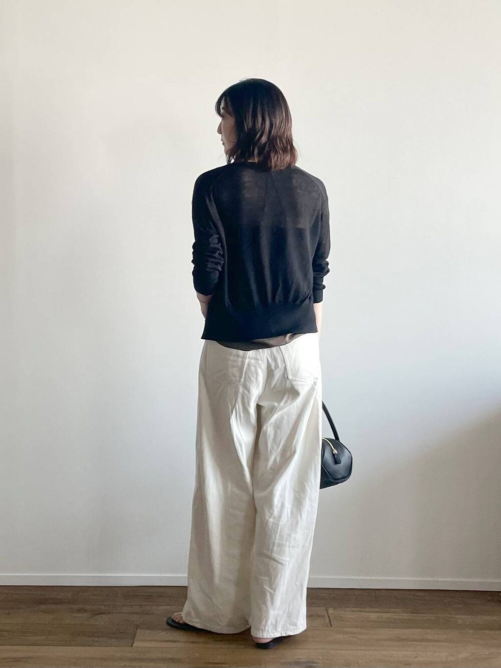 ブラック系のカーディガン/ボレロ、グリーン系のキャミソール、ブラック系のサンダルを着用したレディースの夏コーディネートの3枚目の写真