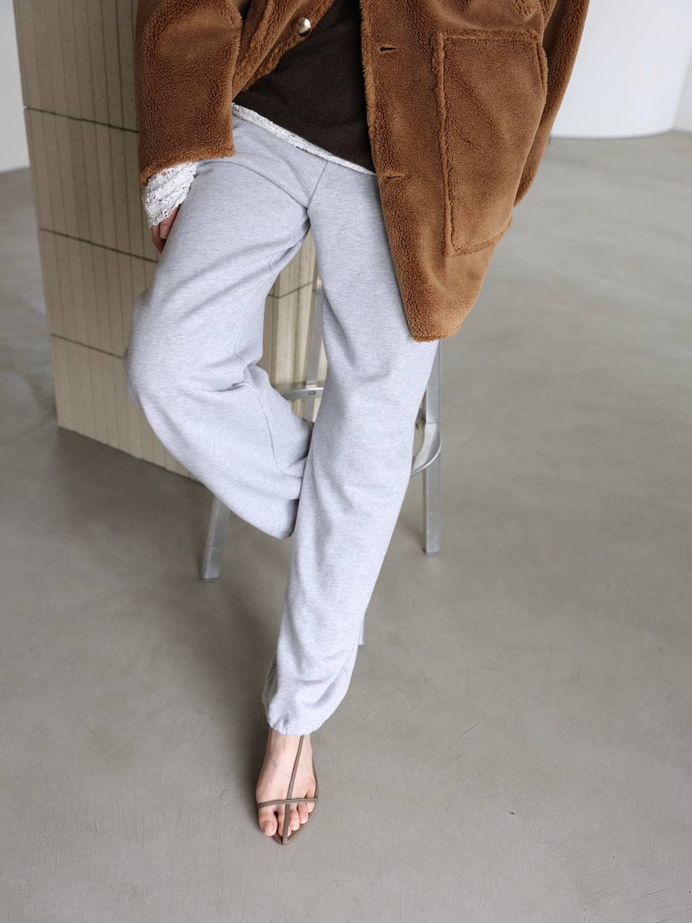 ホワイト系のTシャツ/カットソー、ベージュ系のサンダル、グレー系のスウェットパンツを着用したレディースの秋コーディネートの3枚目の写真