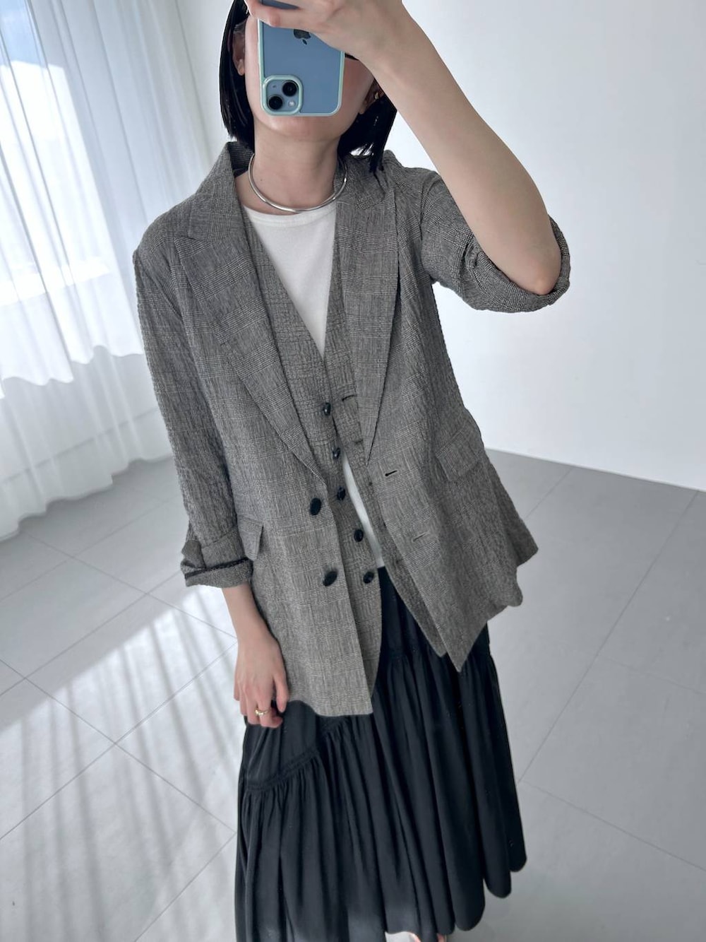 ブラック系のハンドバッグ、ブラック系のテーラードジャケット、ブラック系のベストを着用したレディースの冬コーディネートの5枚目の写真