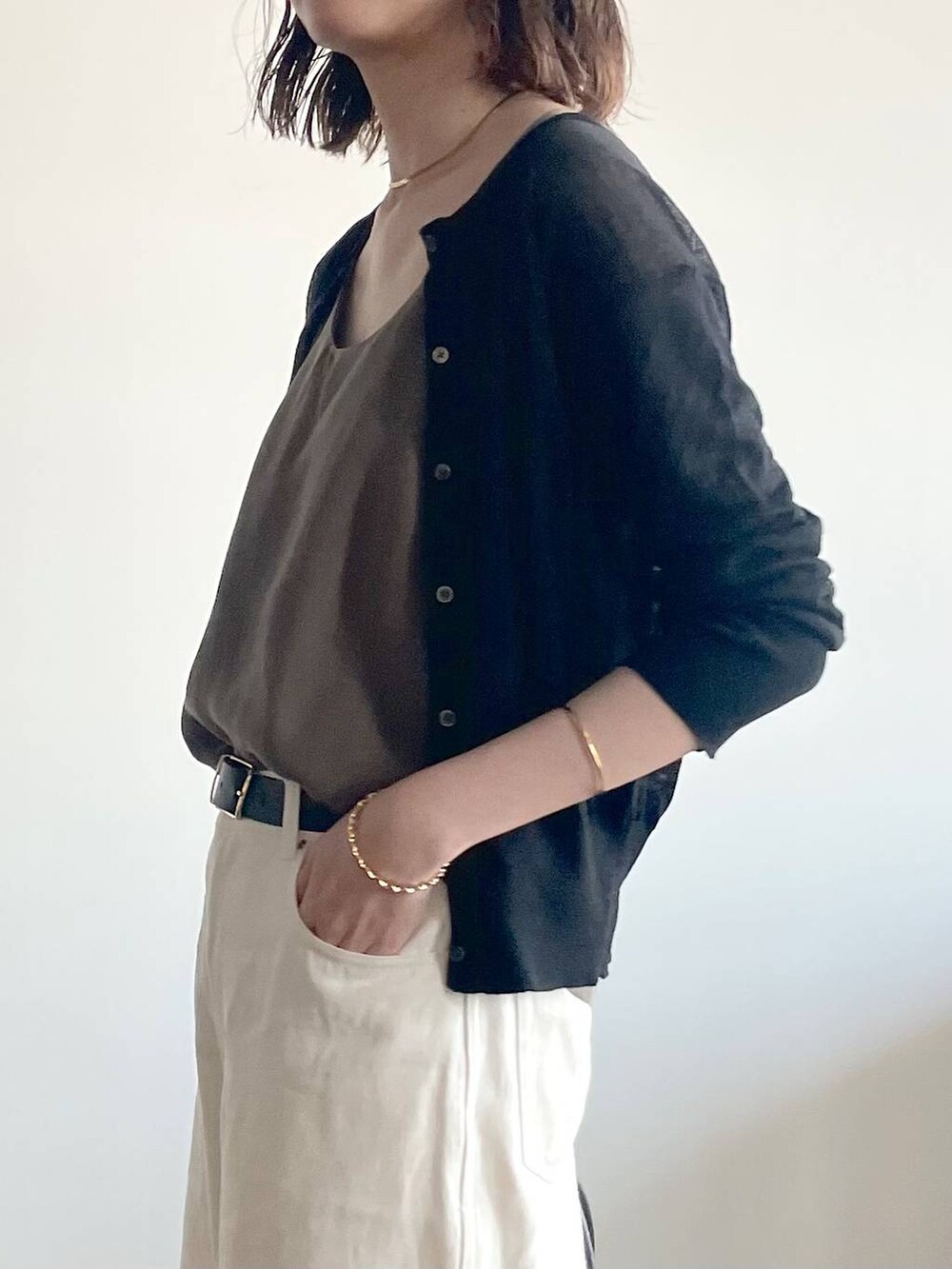 ブラック系のカーディガン/ボレロ、グリーン系のキャミソール、ブラック系のサンダルを着用したレディースの夏コーディネートの5枚目の写真