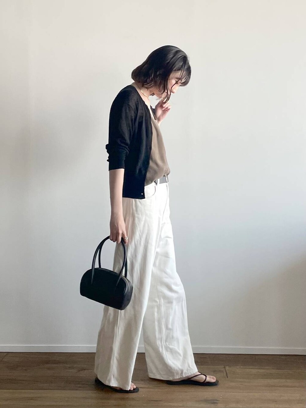 ブラック系のカーディガン/ボレロ、グリーン系のキャミソール、ブラック系のサンダルを着用したレディースの夏コーディネートの2枚目の写真