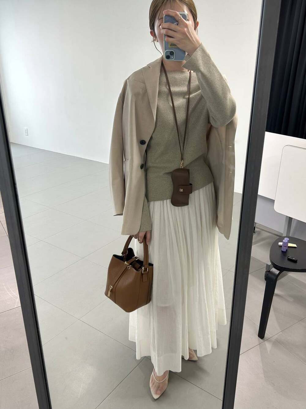 ベージュ系のパンプス、ベージュ系のテーラードジャケット、ホワイト系のスカートを着用したレディースの冬コーディネートの5枚目の写真