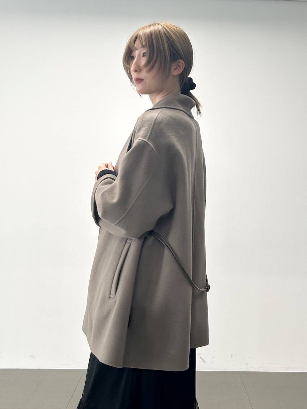 ブラック系のボストンバッグ、ブラウン系のピーコート、ブラック系のニット/セーターを着用したレディースの冬コーディネートの5枚目の写真