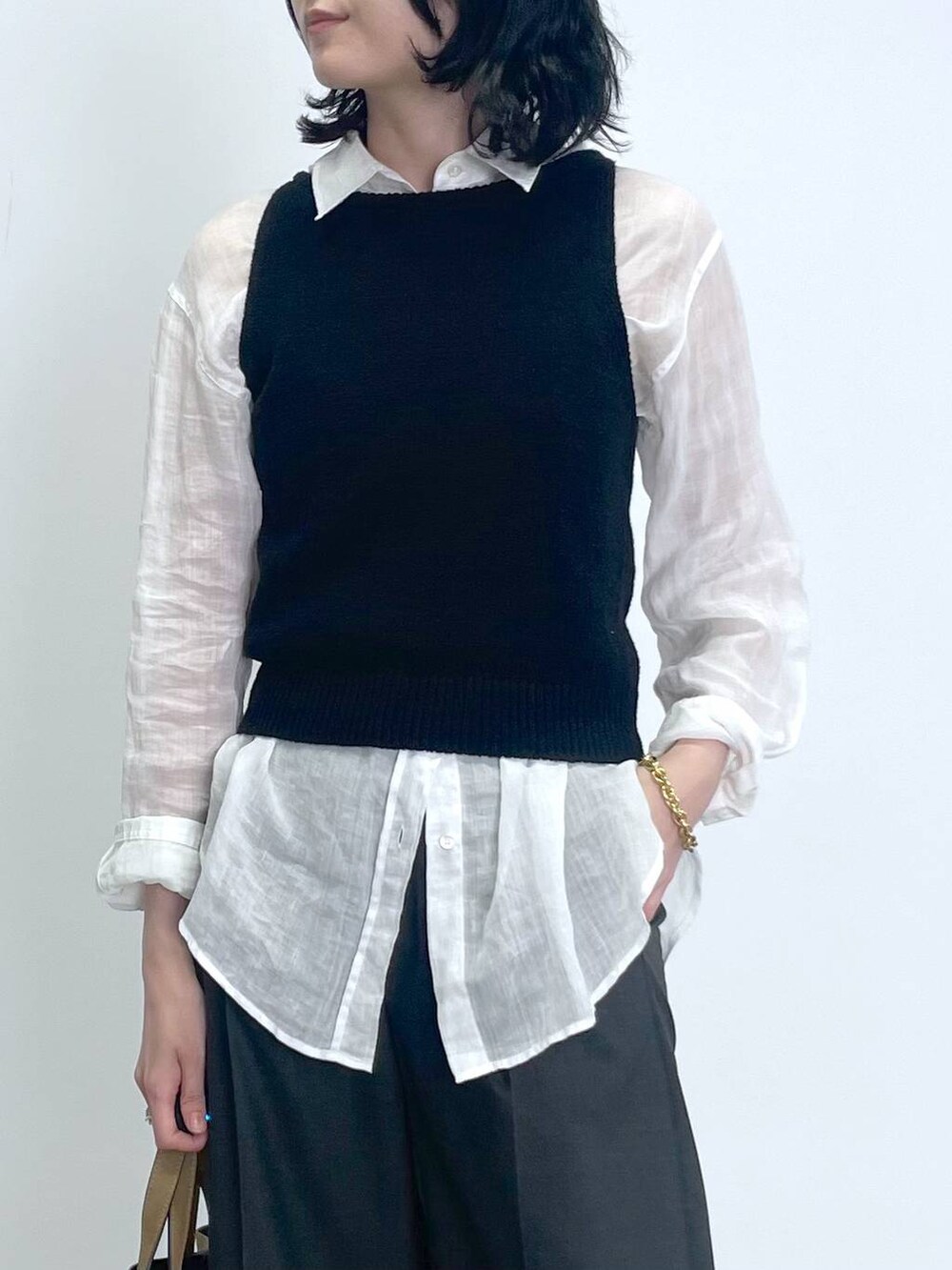 ブラック系のタンクトップ、ホワイト系のシャツ/ブラウス、ブラウン系のトートバッグを着用したレディースの秋コーディネートの3枚目の写真