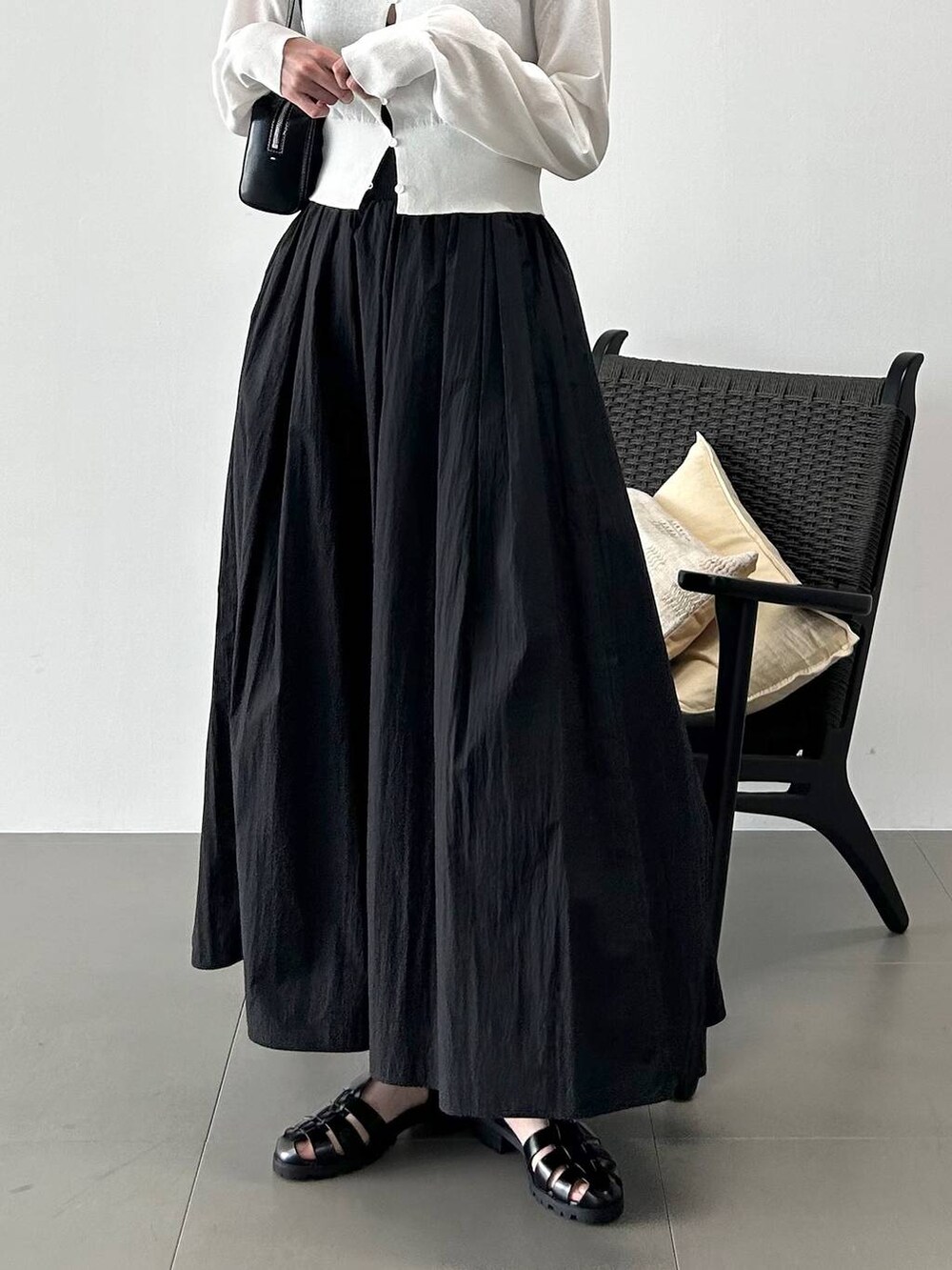 ホワイト系のカーディガン/ボレロ、ブラック系のサンダル、ブラック系のスカートを着用したレディースの春コーディネートの5枚目の写真