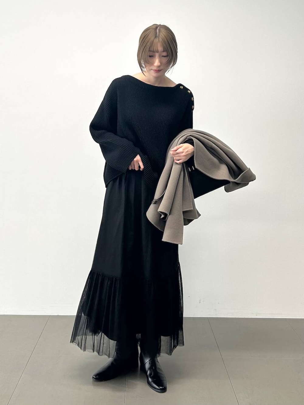 ブラック系のボストンバッグ、ブラウン系のピーコート、ブラック系のニット/セーターを着用したレディースの冬コーディネートの7枚目の写真