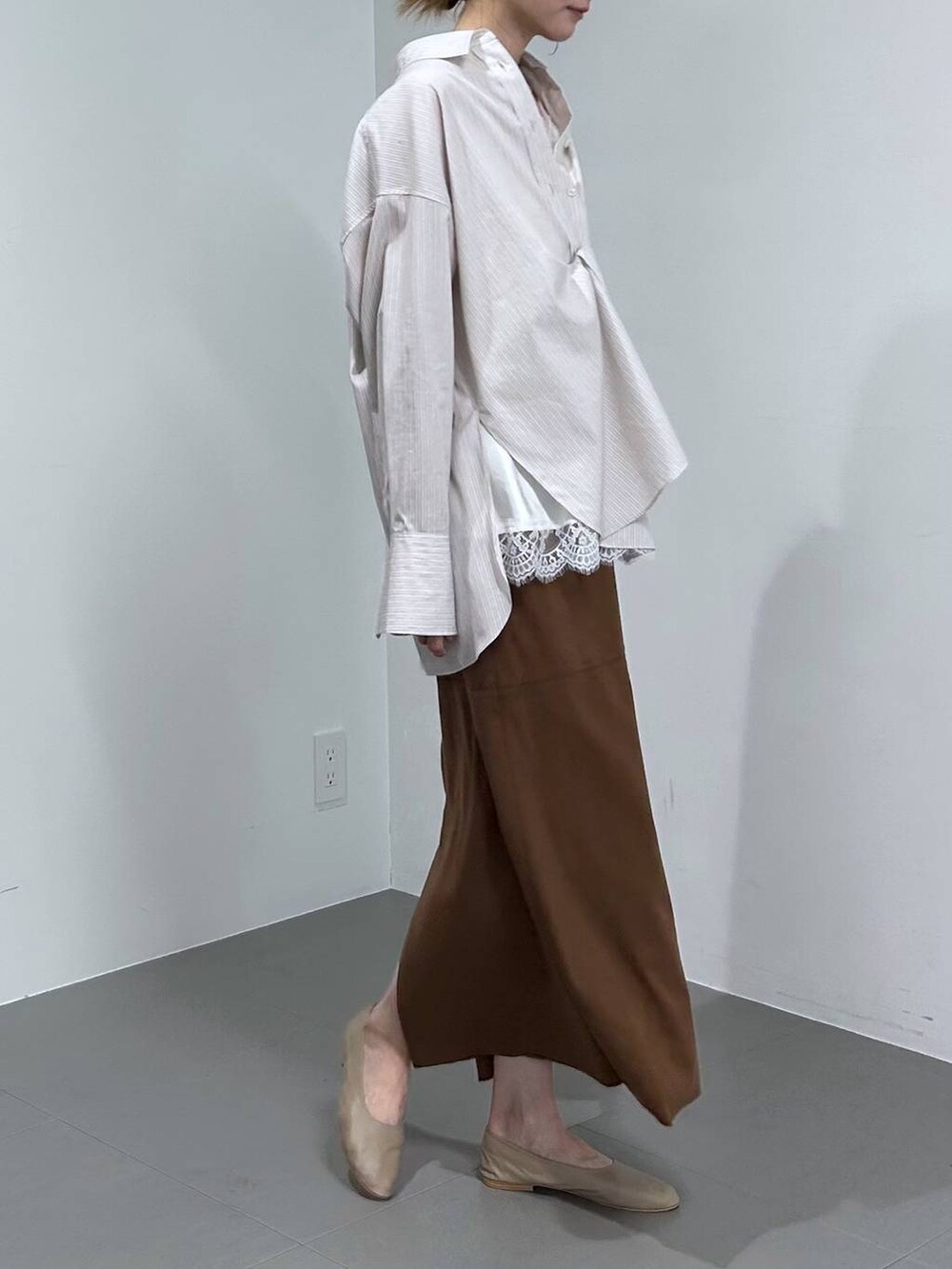 イエロー系のスカート、ベージュ系のシャツ/ブラウス、ブラウン系のショルダーバッグを着用したレディースの冬コーディネートの5枚目の写真