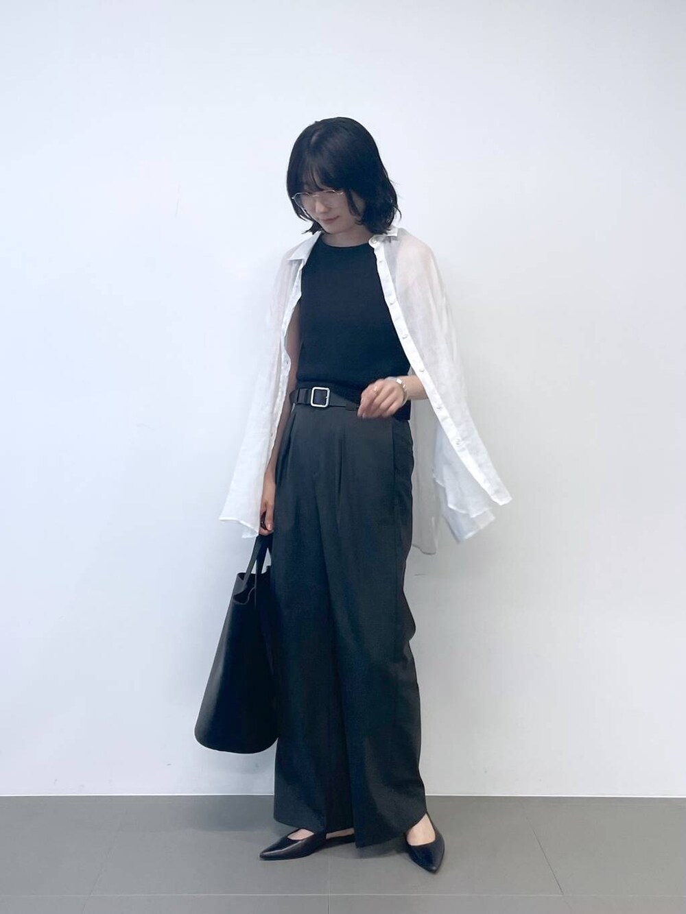 ブラック系のタンクトップ、ホワイト系のシャツ/ブラウス、ブラック系のトートバッグを着用したレディースの夏コーディネートの3枚目の写真