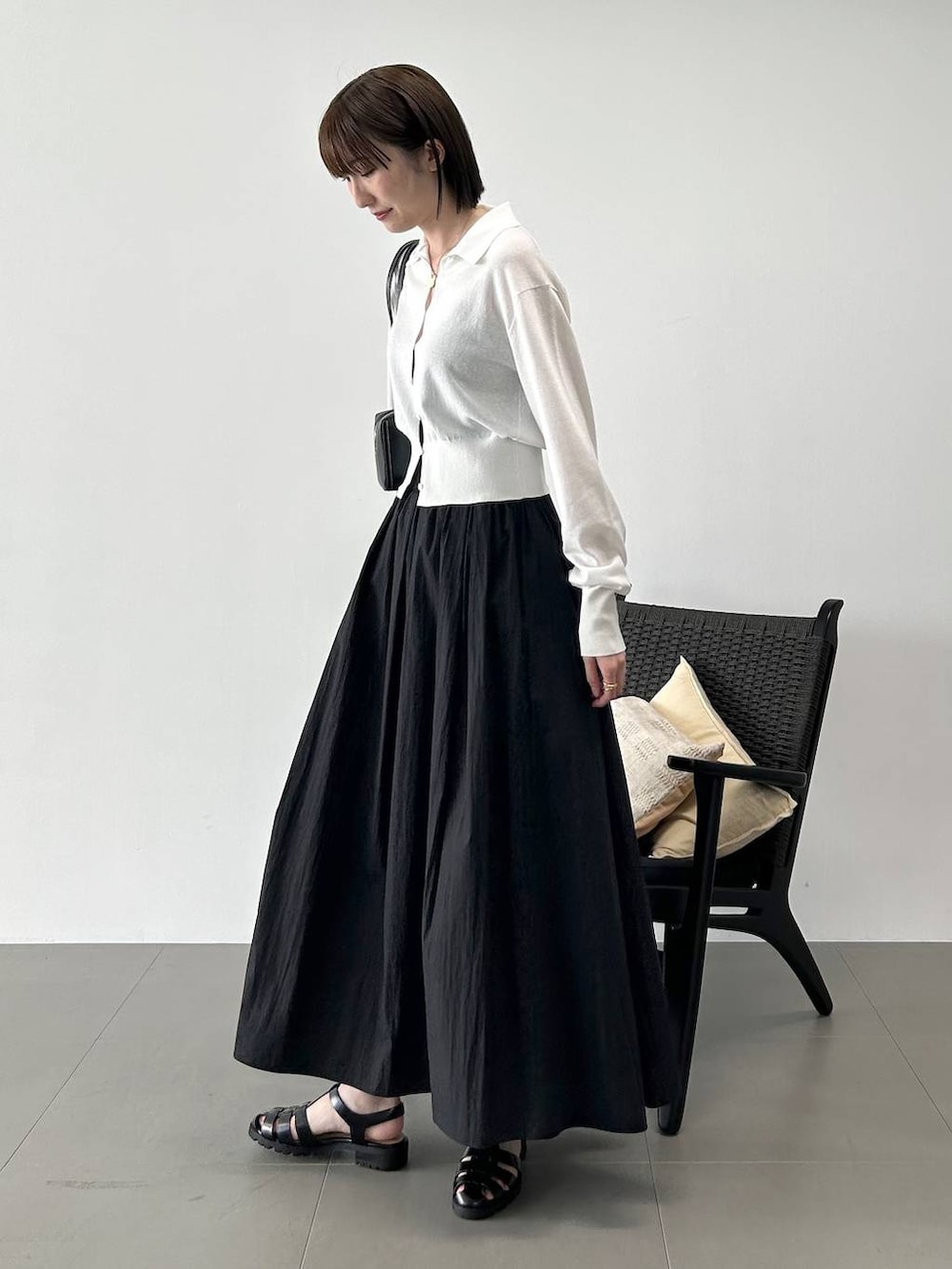 ホワイト系のカーディガン/ボレロ、ブラック系のサンダル、ブラック系のスカートを着用したレディースの春コーディネートの2枚目の写真