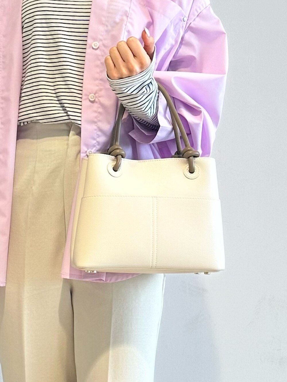 ピンク系のシャツ/ブラウス、ホワイト系のTシャツ/カットソー、ベージュ系のその他パンツを着用したレディースの春コーディネートの4枚目の写真