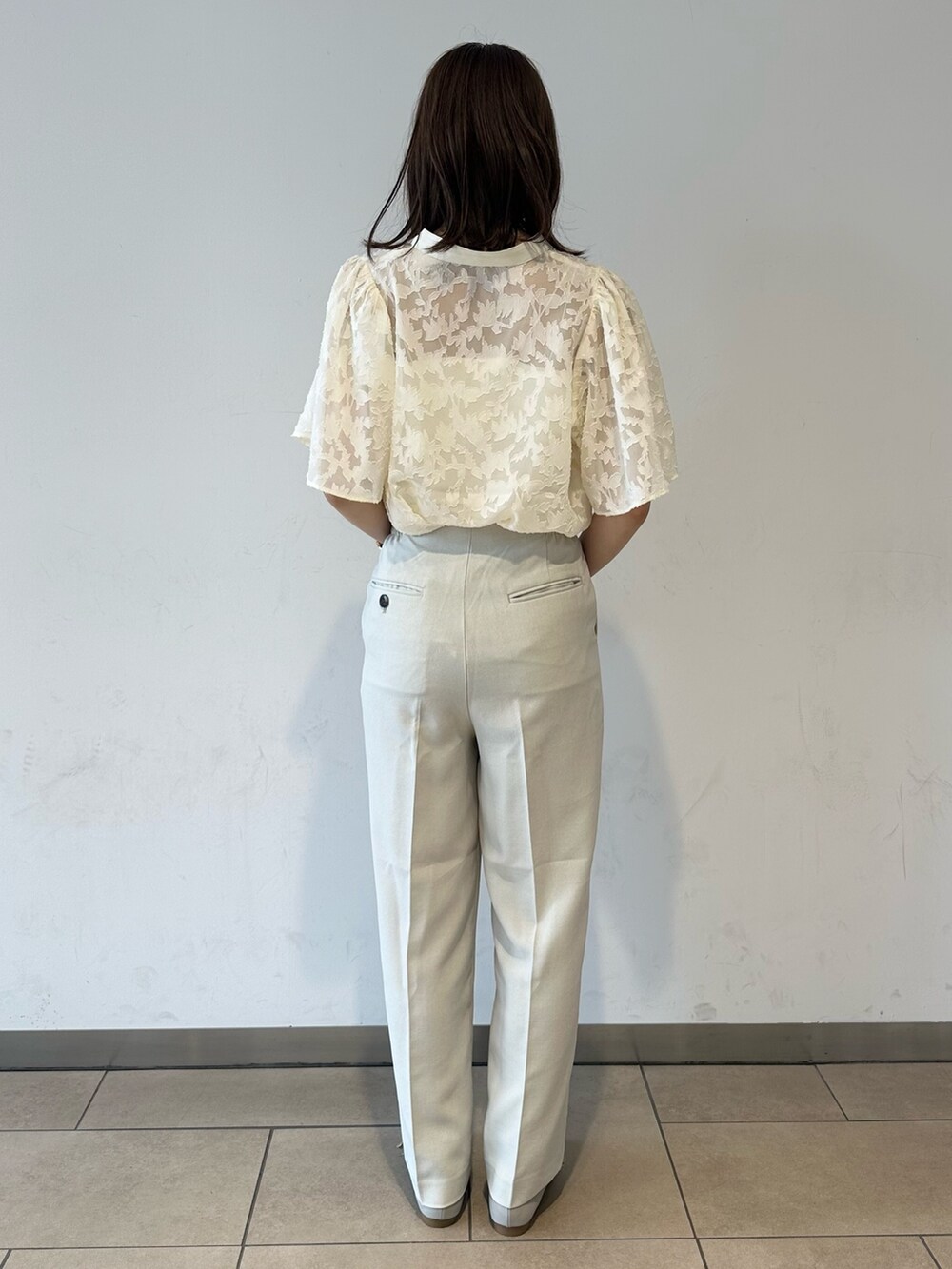 ベージュ系のその他パンツ、グレー系のドレスシューズ、ホワイト系のキャミソールを着用したレディースの夏コーディネートの3枚目の写真