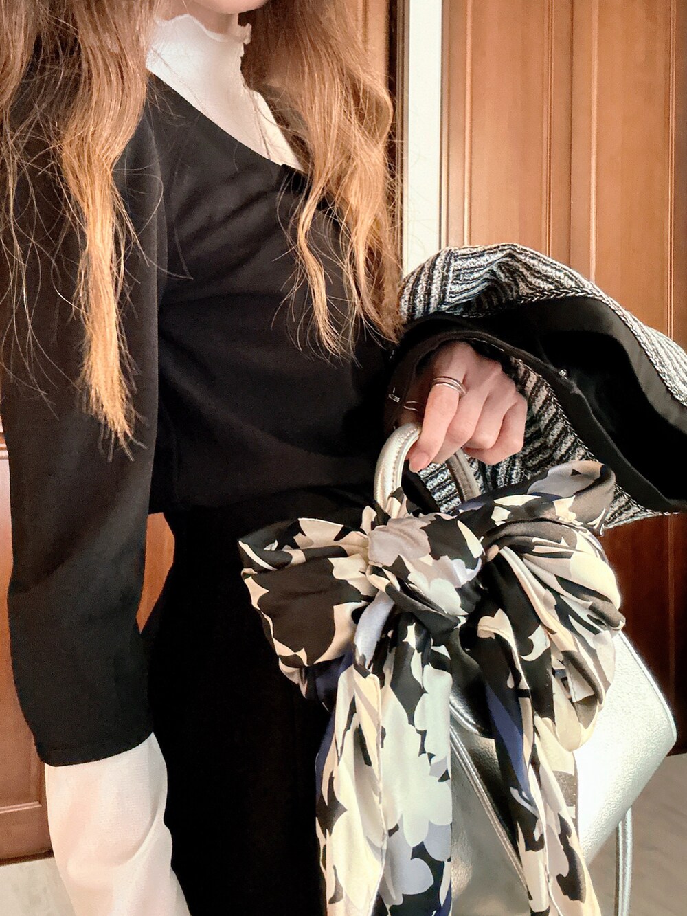 ブラック系のスーツセット、グレー系のクラッチバッグ、ブラック系のベルトを着用したレディースの春コーディネートの5枚目の写真