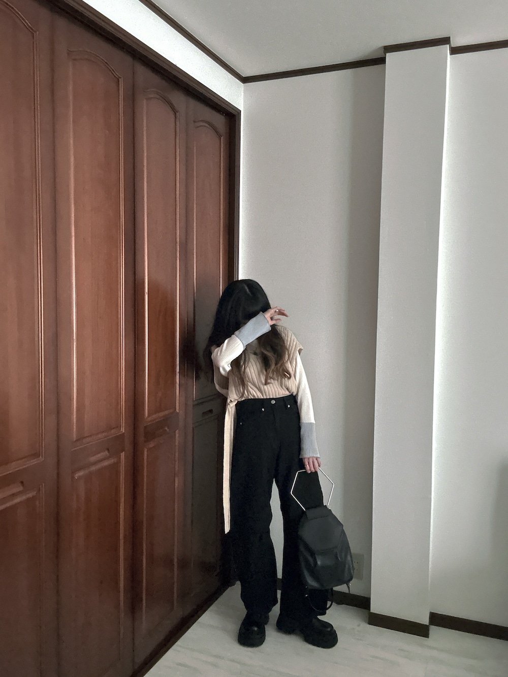 ブラック系のデニムパンツ、ホワイト系のTシャツ/カットソー、ベージュ系のベストを着用したレディースの春コーディネートの3枚目の写真