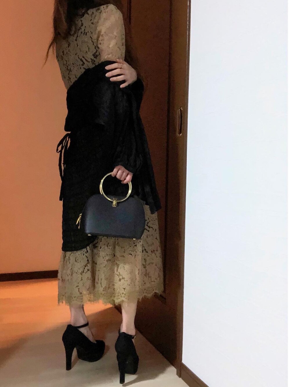 ベージュ系のドレス、ブラック系のパンプス、ブラック系のハンドバッグを着用したレディースの冬コーディネートの4枚目の写真