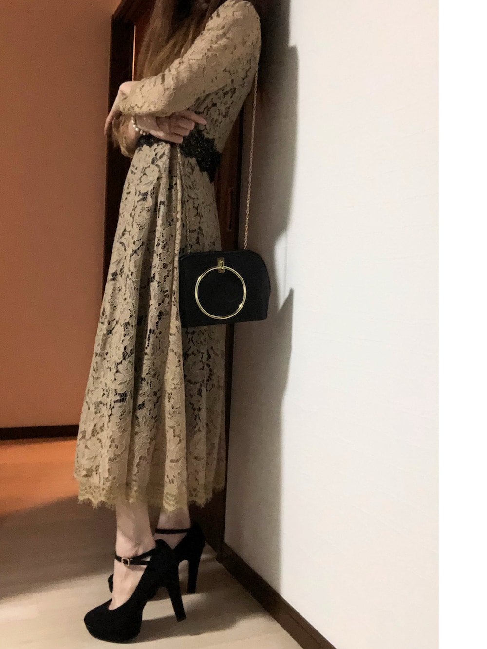 ベージュ系のドレス、ブラック系のパンプス、ブラック系のハンドバッグを着用したレディースの冬コーディネートの3枚目の写真