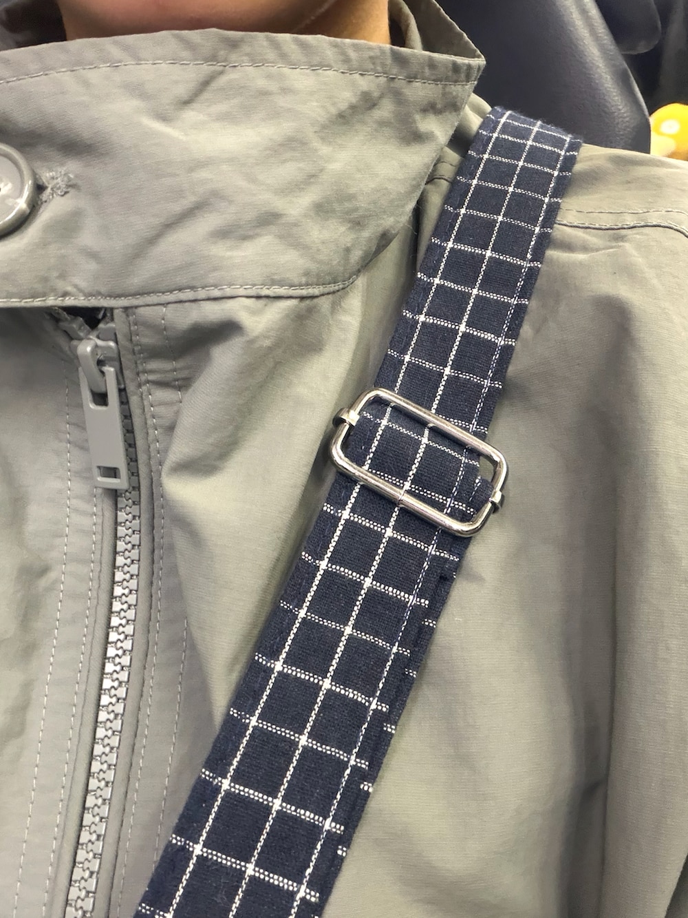 グレー系のスカート、その他のナイロンジャケット、ブラック系のスニーカーを着用したレディースの春コーディネートの2枚目の写真