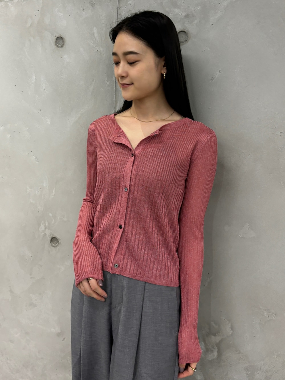 ピンク系のカーディガン/ボレロ、グレー系のスラックスを着用したレディースの秋コーディネートの2枚目の写真