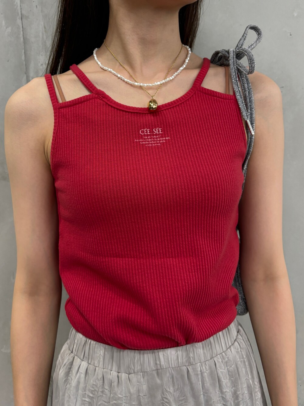 レッド系のタンクトップ、グレー系のスカート、シルバー系のショルダーバッグを着用したレディースの夏コーディネートの3枚目の写真