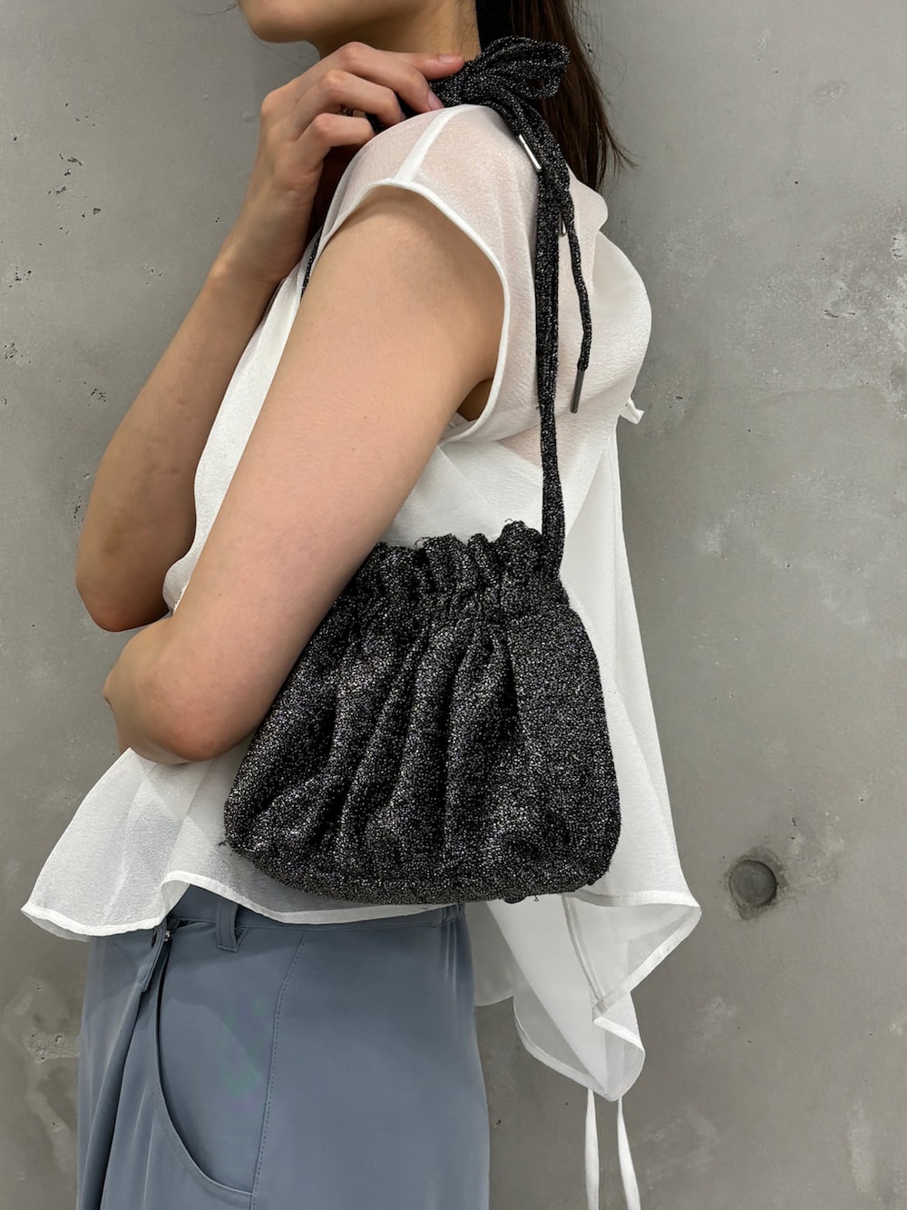 ブラック系のショルダーバッグ、ホワイト系のシャツ/ブラウス、ブルー系のその他パンツを着用したレディースの夏コーディネートの4枚目の写真