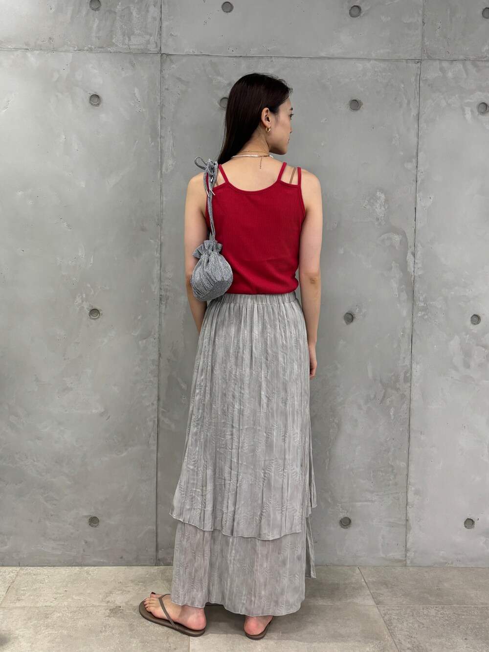 レッド系のタンクトップ、グレー系のスカート、シルバー系のショルダーバッグを着用したレディースの夏コーディネートの2枚目の写真