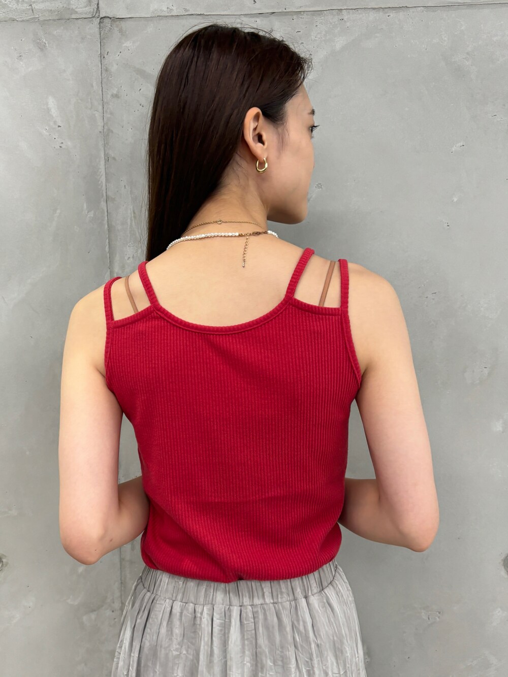 レッド系のタンクトップ、グレー系のスカート、シルバー系のショルダーバッグを着用したレディースの夏コーディネートの4枚目の写真