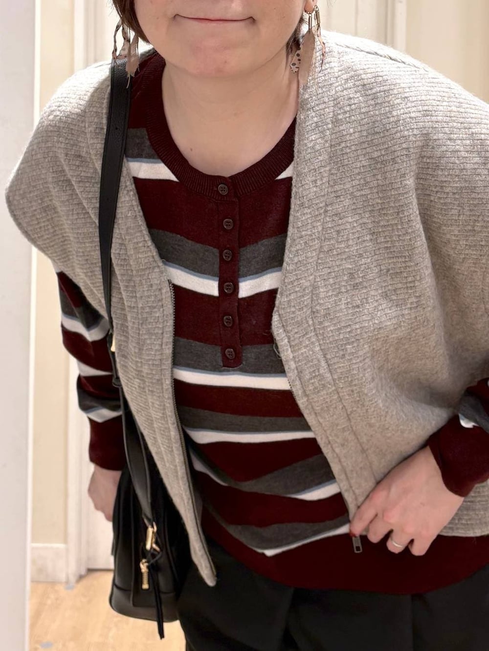 ベージュ系のベスト、レッド系のニット/セーター、ブラック系のパンプスを着用したレディースの秋コーディネートの5枚目の写真