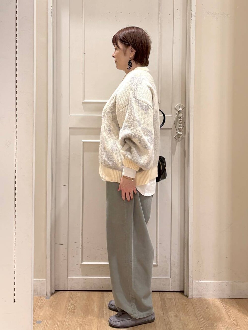 グリーン系のその他パンツ、グレー系のモカシン/デッキシューズ、ブラック系のトートバッグを着用したレディースの秋コーディネートの2枚目の写真