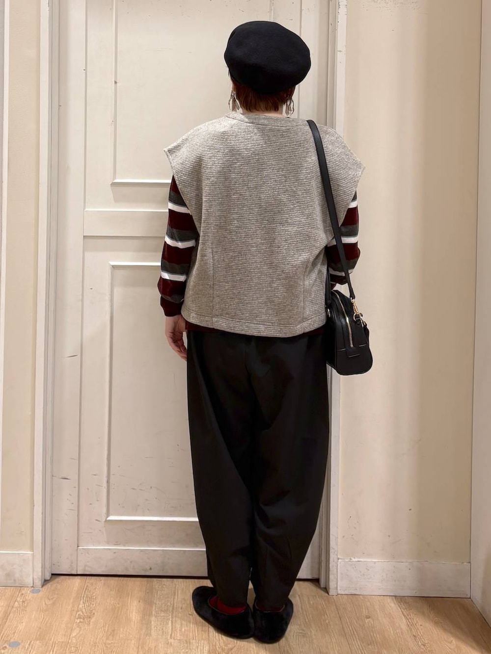 ベージュ系のベスト、レッド系のニット/セーター、ブラック系のパンプスを着用したレディースの秋コーディネートの4枚目の写真