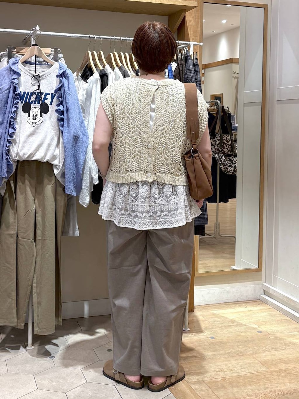 ベージュ系のトートバッグ、ベージュ系のベスト、ベージュ系のその他パンツを着用したレディースの夏コーディネートの3枚目の写真