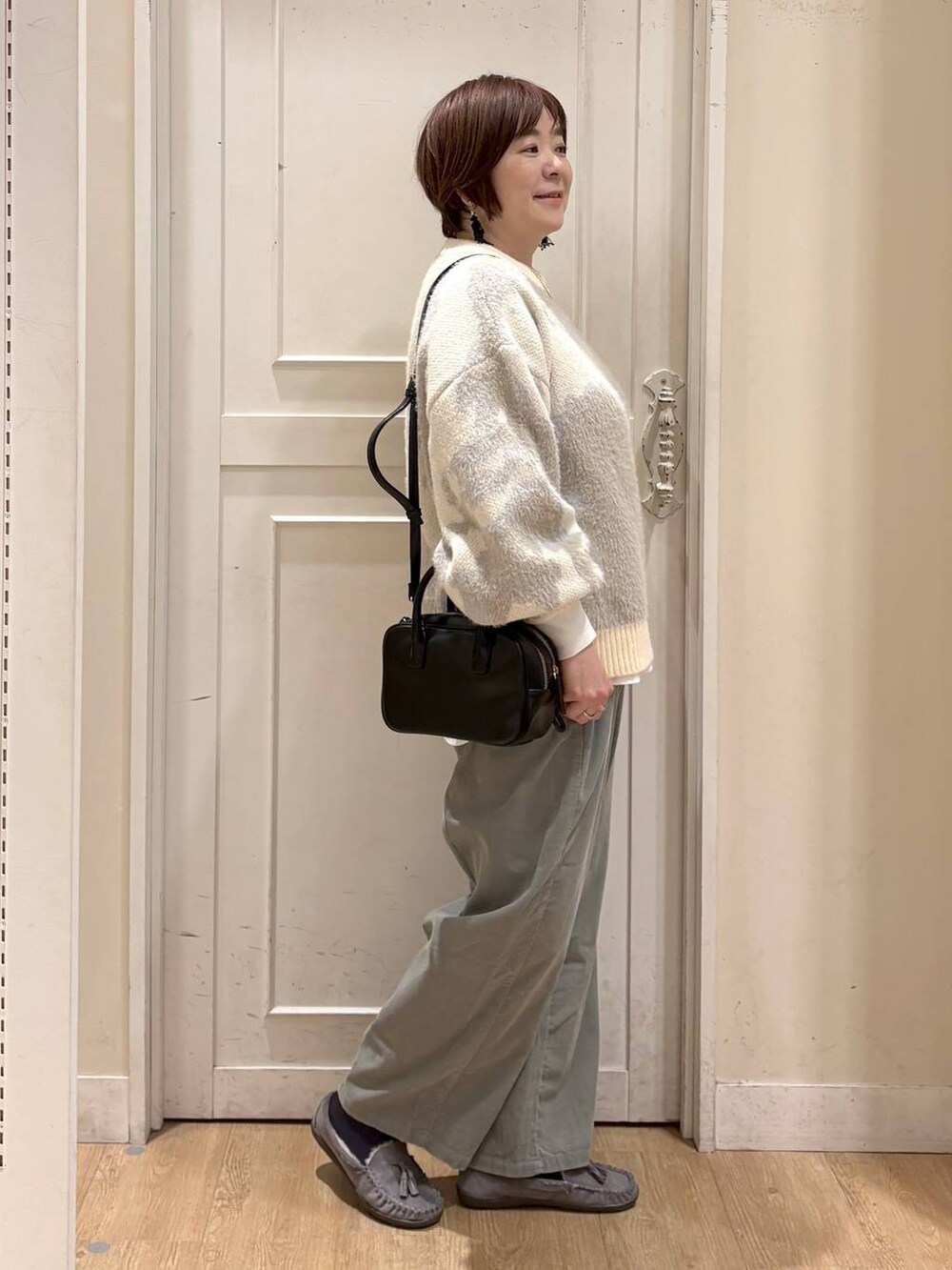 グリーン系のその他パンツ、グレー系のモカシン/デッキシューズ、ブラック系のトートバッグを着用したレディースの秋コーディネートの6枚目の写真