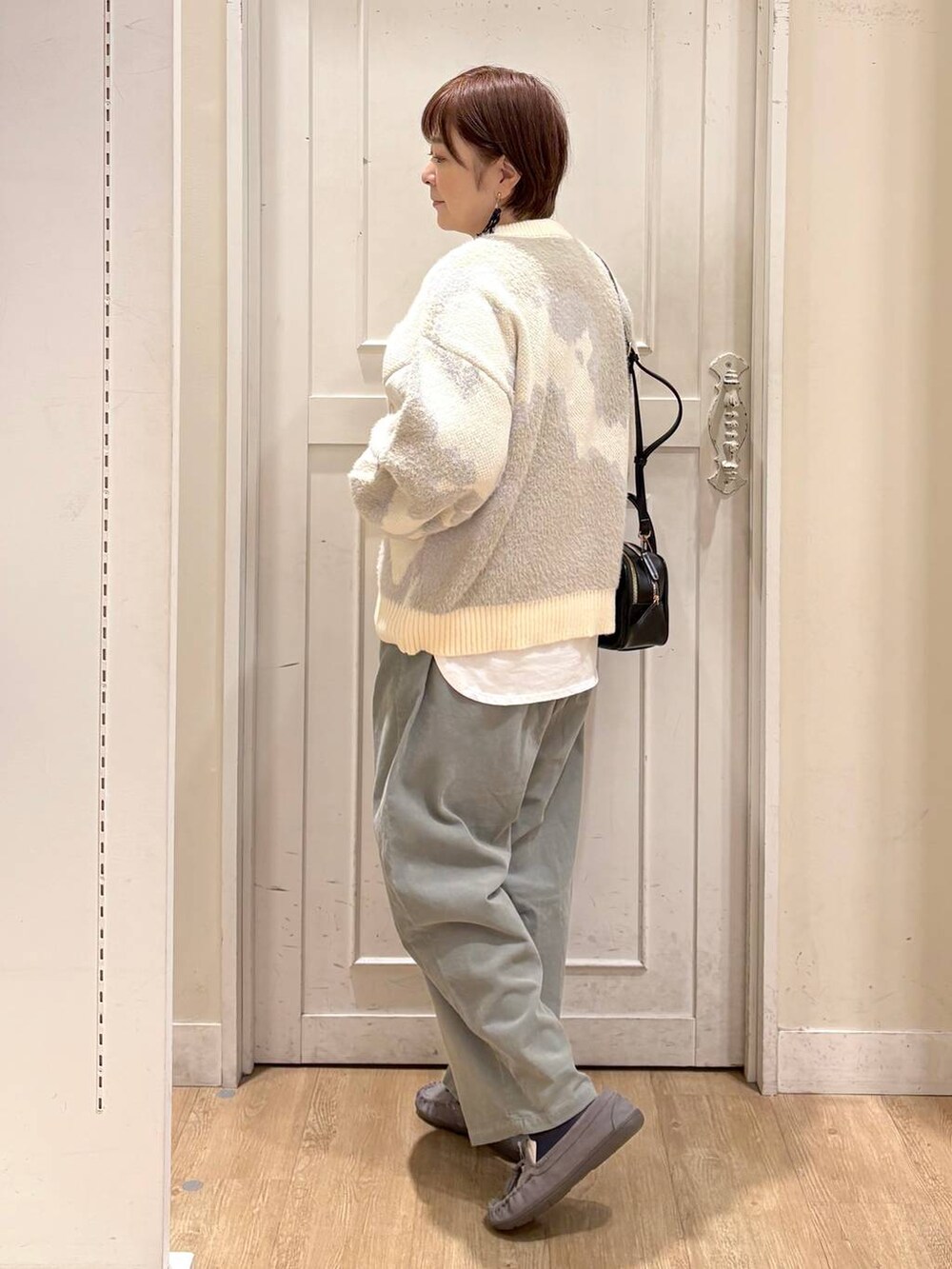 グリーン系のその他パンツ、グレー系のモカシン/デッキシューズ、ブラック系のトートバッグを着用したレディースの秋コーディネートの3枚目の写真
