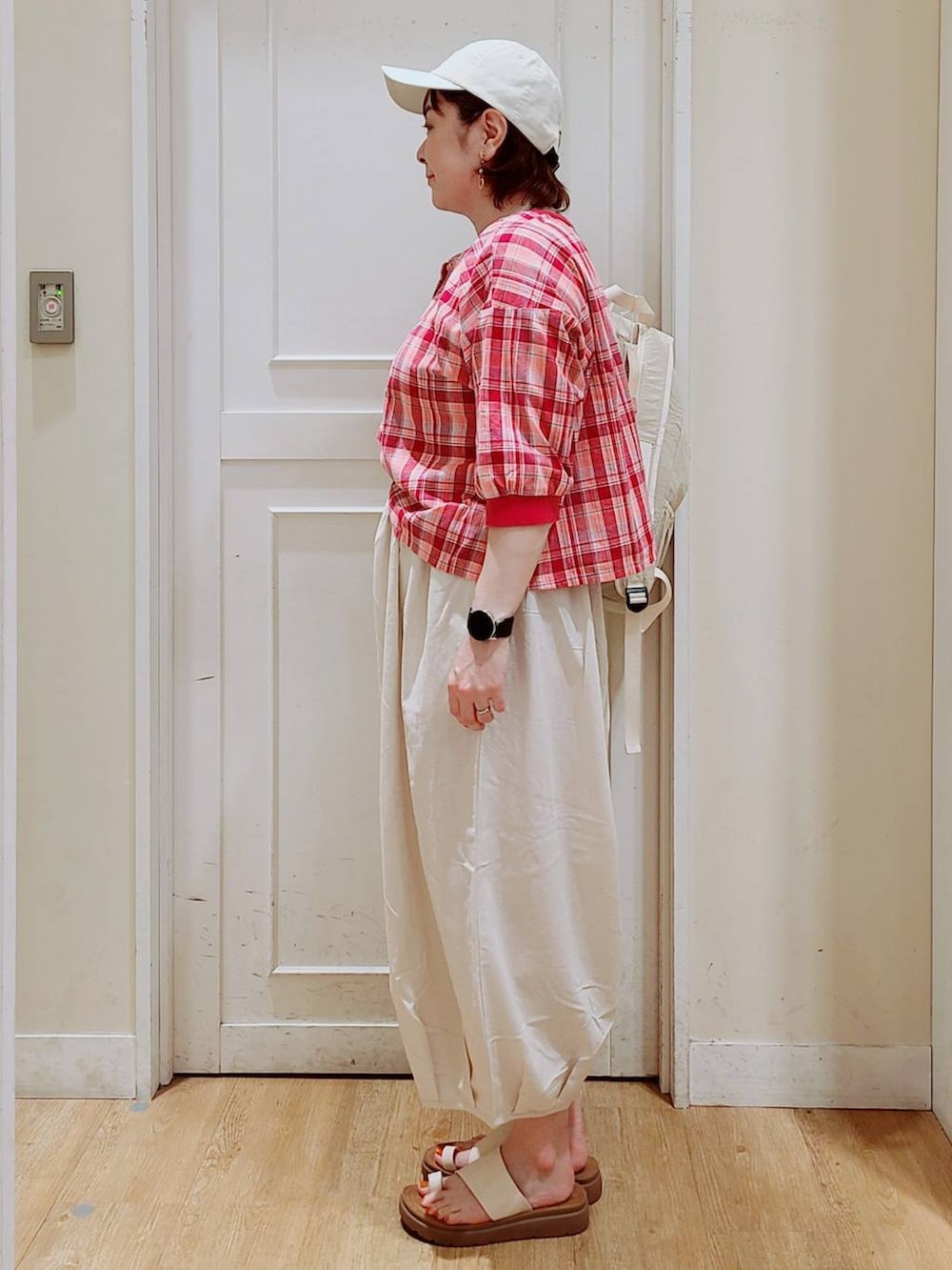 ホワイト系のサンダル、その他のシャツ/ブラウス、ホワイト系のバックパック/リュックを着用したレディースの夏コーディネートの2枚目の写真