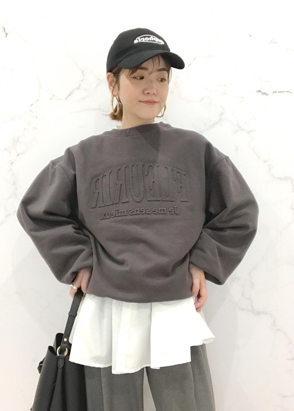 ブラック系のローファー、ブラック系のショルダーバッグ、グレー系のスラックスを着用したレディースの冬コーディネートの7枚目の写真
