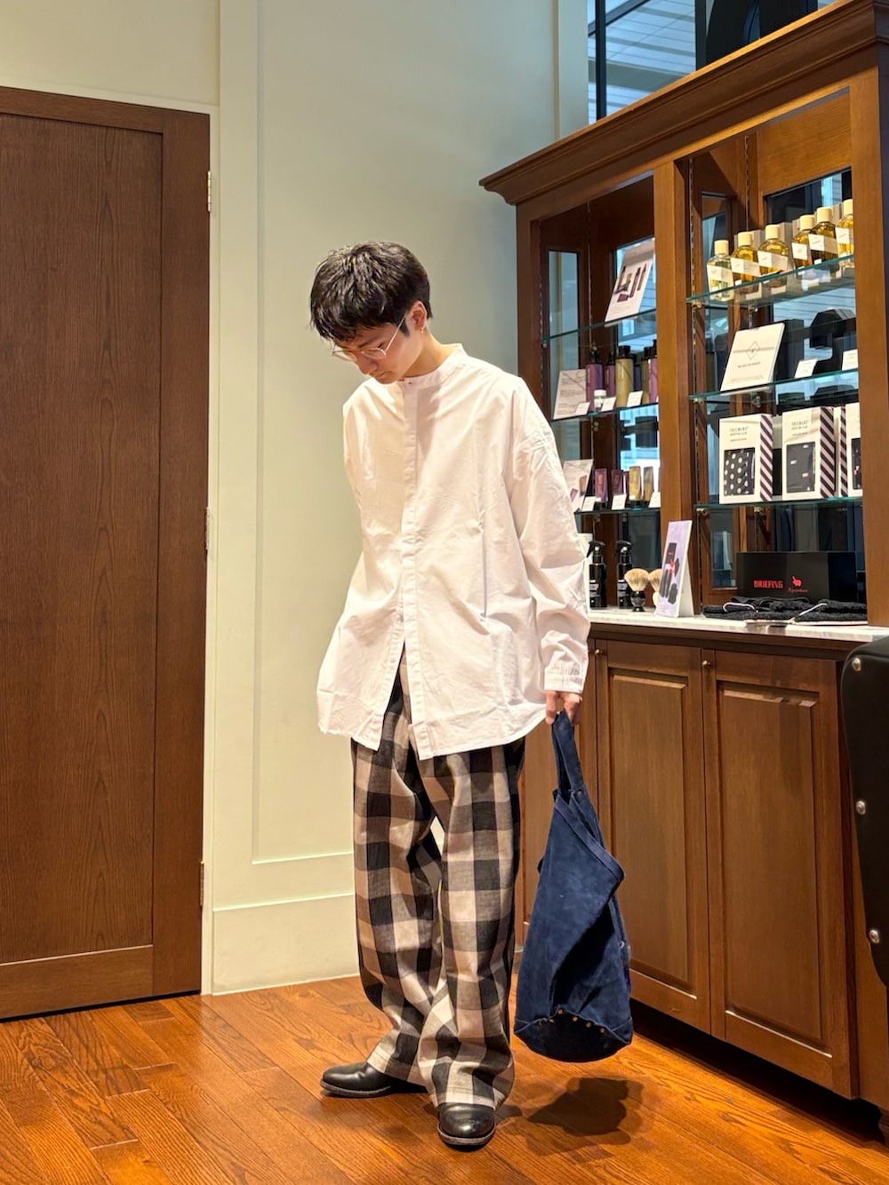 ホワイト系のシャツ/ブラウス、ホワイト系のパンツ、ブルー系のトートバッグを着用したメンズの春コーディネートの5枚目の写真